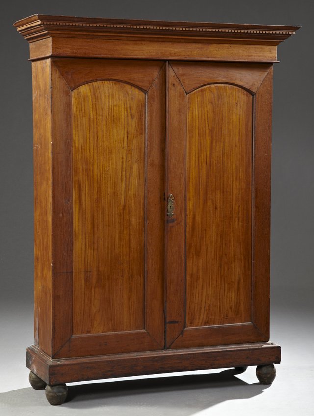 Diminutive English Carved Mahogany Cupboard, 19th c.,: Diminutive English Carved Mahogany Cupboard, 19th c., with a dentillated ogee crown over double doors opening to an interior with two shelves and a belt of two drawers, on a plinth base on turned bun 