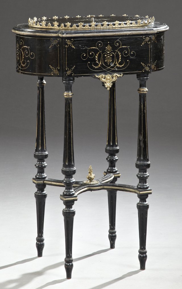 Ebonized Jardiniere Table, c. 1880, with incised: Ebonized Jardiniere Table, c. 1880, with incised decoration, the oval lid covering a tole planter, on a base with gilt incised decoration on tapered reeded legs joined by an X-form stretcher with a ce