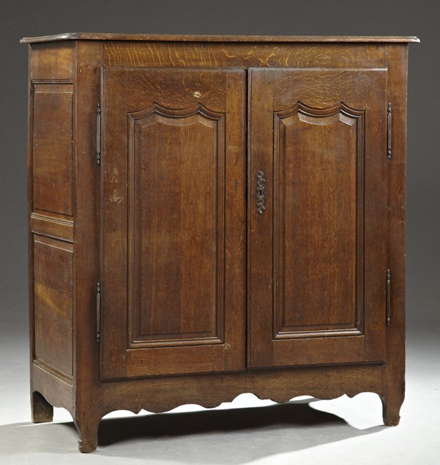 Louis XV Style Oak Cupboard, 19th c., the rpounded: Louis XV Style Oak Cupboard, 19th c., the rpounded corner and edge top over double fielded panel doiors with steel fiche hinges and a single escutcheon, on short shaped feet joined by a shaped stretch