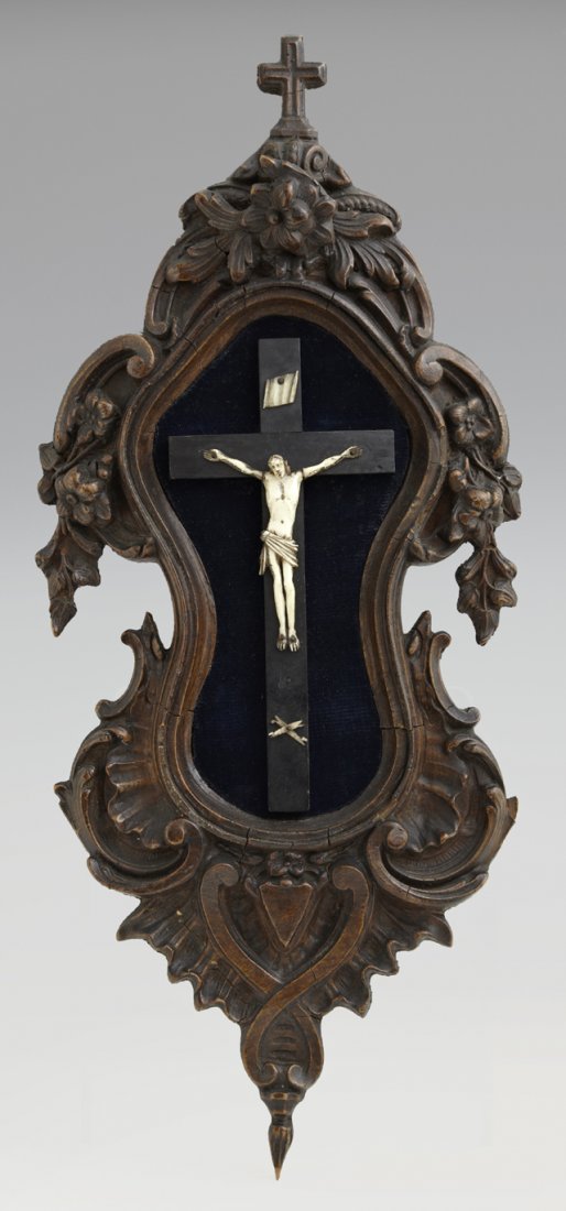 French Carved Beech Crucifix, early 20th c., with a: French Carved Beech Crucifix, early 20th c., with a faux ivory Jesus, on a shaped back plate with a floral and shell carved border, H.- 15 5/8 in., W.- 7 in., D.- 2 1/8 in.