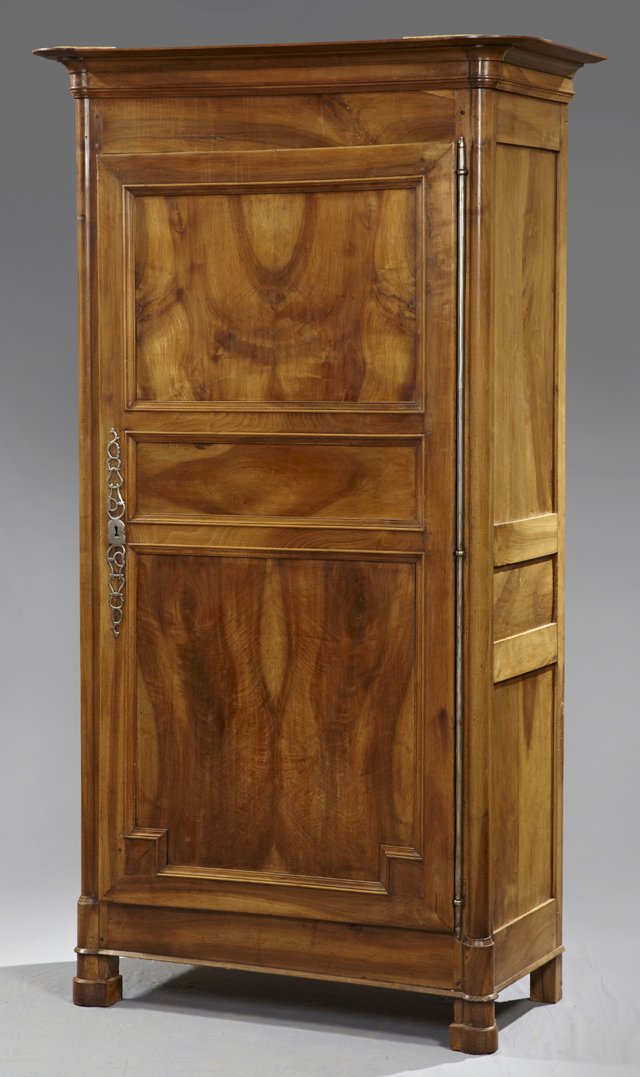 Louis Philippe Carved Walnut Bonnetiere, c. 1850, the: Louis Philippe Carved Walnut Bonnetiere, c. 1850, the stepped rounded corner ogee crown over a three panel door with a long steel escutcheon and a long steel fiche hinge, flanked by edge columns, the 