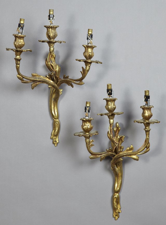 Pair of Bronze Louis XV Style Three Light Sconces, 19th: Pair of Bronze Louis XV Style Three Light Sconces, 19th c.,with floriform candle cups and bobeches on leaf relief scrolling arms, emanating from a leaf form back plate, H.- 16 1/4 in., W.- 11 in., D.-
