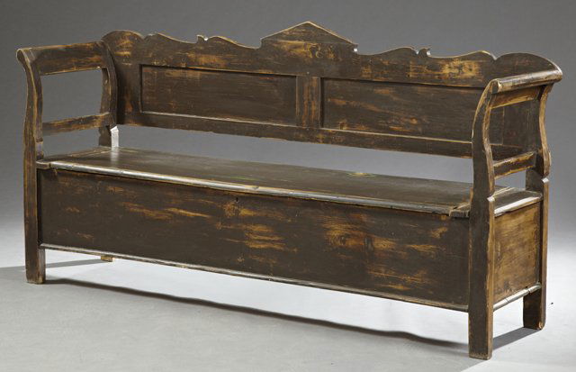 French Provincial Carved Pine Settle, 19th c., with a: French Provincial Carved Pine Settle, 19th c., with a peaked crest over a shaped back with curved handles, the seat lifting to open storage, H.- 39 3/4 in., W.- 76 in., D.- 21 in.