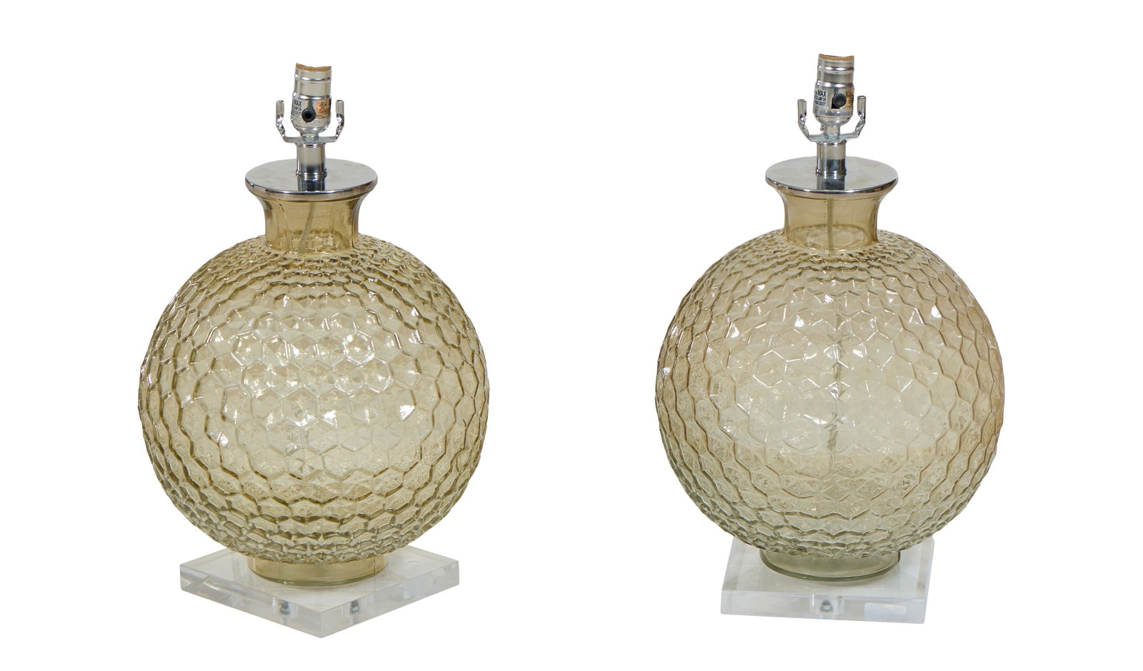 Pair Of Contemporary Glass Lamps, 21st c., Each- H.- 19 in., Dia.- 14 in.; Base: W.- 7 in., D.- 7: Pair Of Contemporary Glass Lamps, 21st c., the sphere forms with graduated hexagonal dimples, lucite bases, slight amber tone, Each- H.- 19 in., Dia.- 14 in.; Base: W.- 7 in., D.- 7 in. (2 Pcs.)