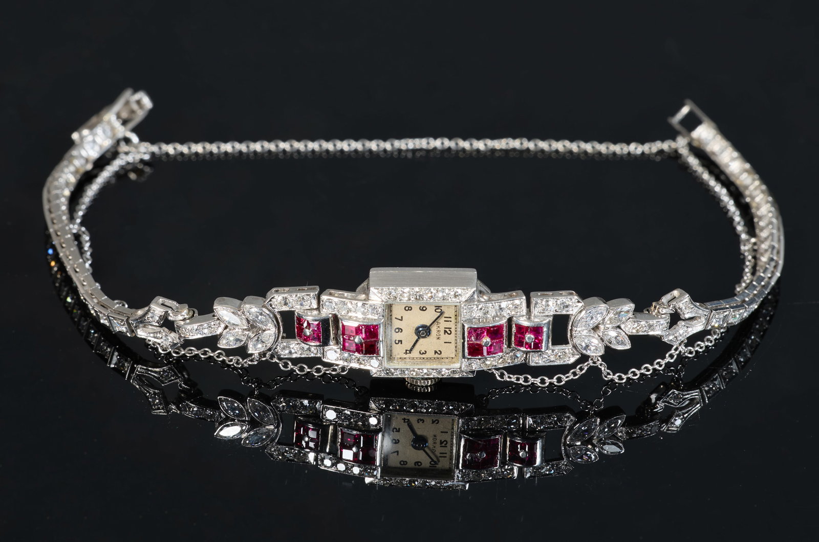 Ladies' Art Deco Akron Platinum and Palladium Diamond and Ruby Wristwatch, early 20th c., Total: Ladies' Art Deco Akron Platinum and Palladium Diamond and Ruby Wristwatch, early 20th c., the square platinum watch consisting of four sections of princess cut rubies on either side of the dial compos