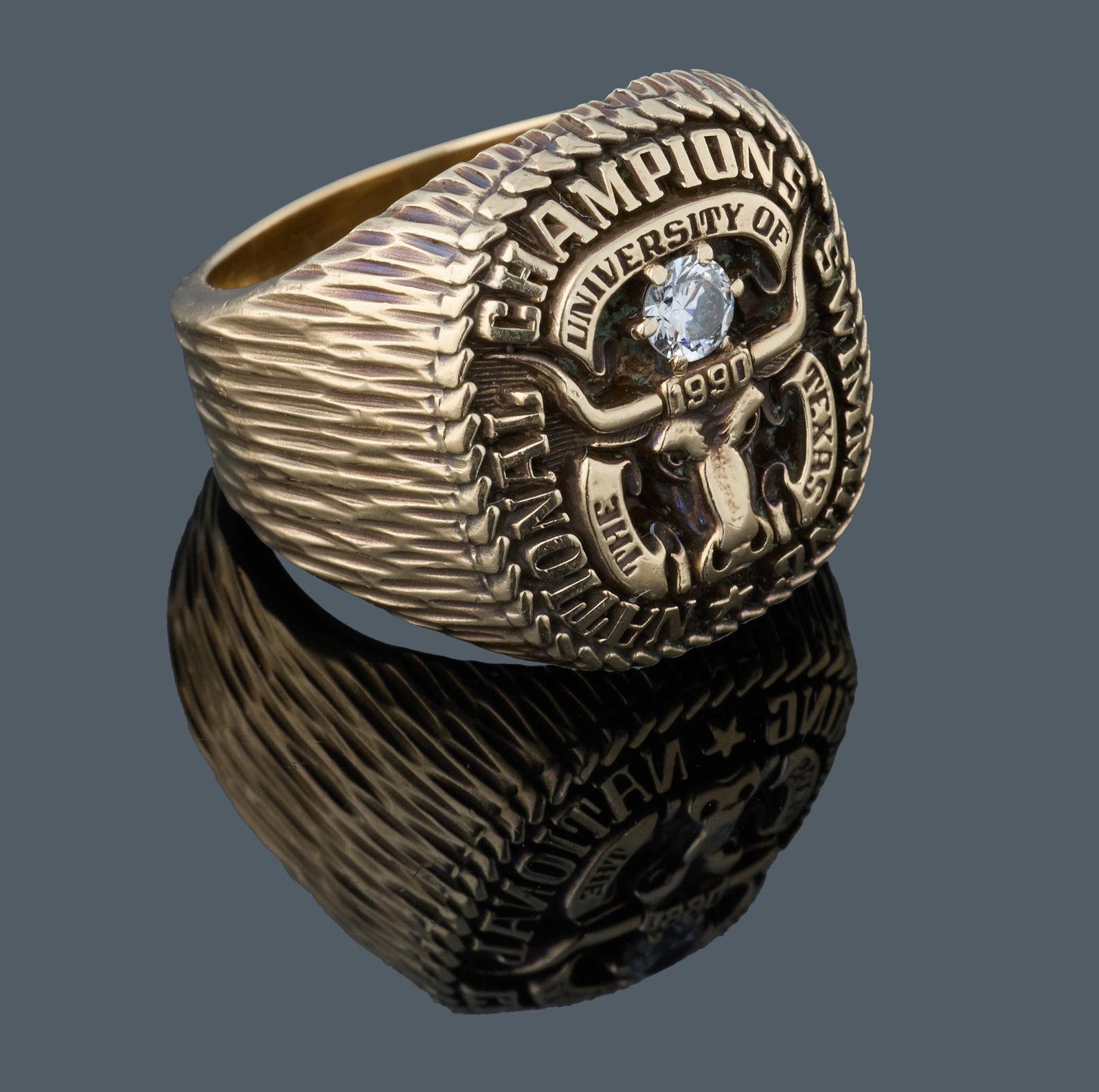 Men's 10K Yellow Gold University of Texas Swimming National Champions Ring, 1990, App. Total Wt.-: Men's 10K Yellow Gold University of Texas Swimming National Champions Ring, 1990, by Balfour, mounted with an app. 0.2 carat round brilliant cut white diamond, inscribed to the original recipient insi