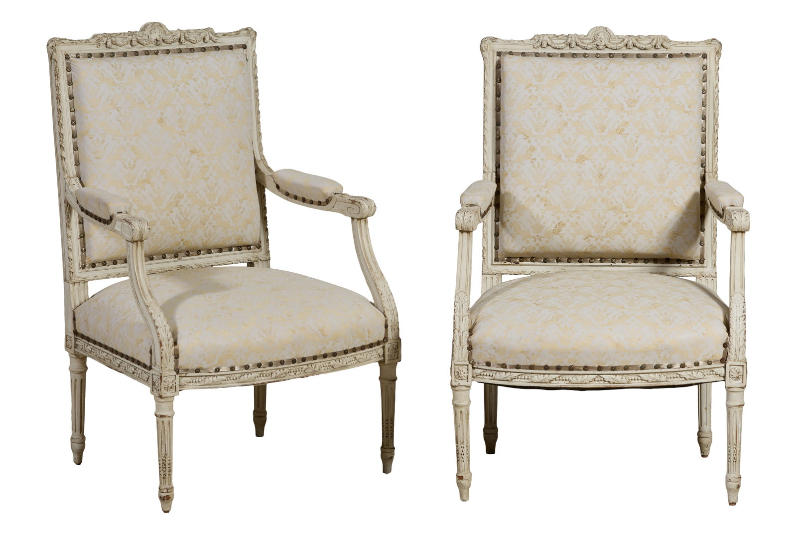 Pair of Fortuny Upholstered French Louis XVI Style Creme Peinte Fauteuils, late 19th c., Each- H.-: Pair of Fortuny Upholstered French Louis XVI Style Creme Peinte Fauteuils, late 19th c., the carved swag upholstered backs into padded scrolled arms, carved seat rail joining ring turned fluted tapere
