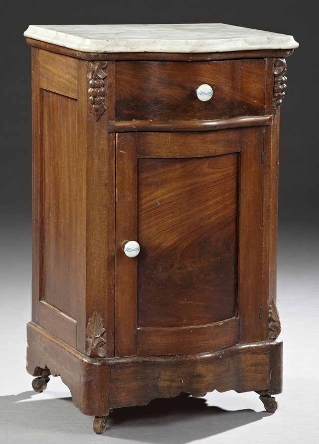 American Late Victorian Carved Mahogany Bow Front: American Late Victorian Carved Mahogany Bow Front Marble Top Night Stand, c. 1890, possibly New Orleans, the rounded corner ogee edge figured white marble above a frieze drawer and a lower cupboard do