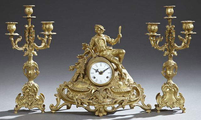 French Style German Gilt Brass Figural Three Piece: French Style German Gilt Brass Figural Three Piece Clock Set, 20th c., by Imperial, the drum clock surmount with a figure of a harvester, over an enamel dial on a relief base with farming tools, wheat
