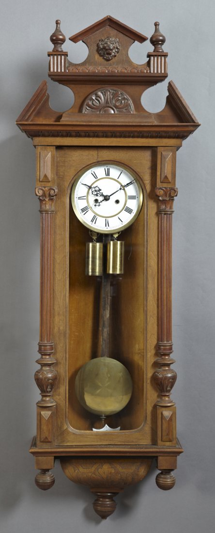 German Carved Mahogany Two Weight Regulator Clock, 19th: German Carved Mahogany Two Weight Regulator Clock, 19th c., with a broken arch crest over an enamel dial and brass weights and pendulum, the bottom with turned finials, H.- 50 in., W.- 17 3/4 in., D.-