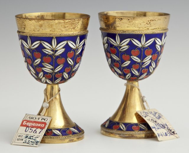 Pair of Russian Gilt Silver and Enamel Footed Vodka: Pair of Russian Gilt Silver and Enamel Footed Vodka Cups, 20th c., the lips with delicate rope banding above enameled fruiting limbs in red, white and royal blue, supported by a flaring base with enam