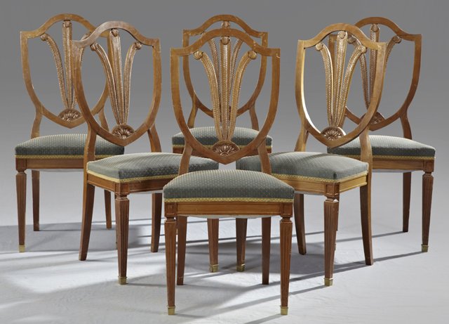 Set of Six Hepplewhite Style Mahogany Side Chairs,: Set of Six Hepplewhite Style Mahogany Side Chairs, early 20th c., the open shield backs with carved "Prince of Wales" feather splats, over upholstered seats on reeded tapered legs with bronze caps, H.