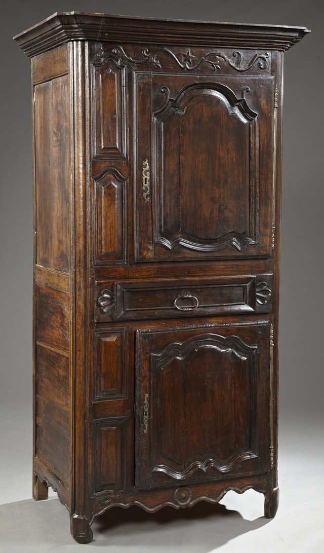 French Provincial Carved Walnut Homme Debout, c. 1750,: French Provincial Carved Walnut Homme Debout, c. 1750, with a stepped shaped ogee crown over a fielded panel cupboard door, with a long steel escutcheon and a long steel fiche hinge over a carved cent