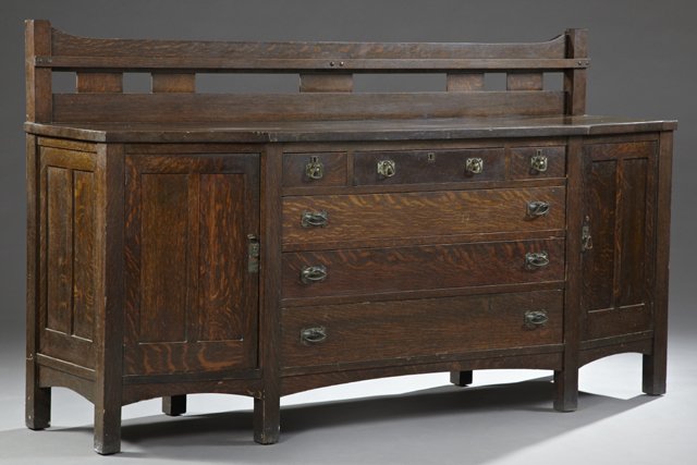 American Mission Oak Sideboard, c. 1910, Limbert: American Mission Oak Sideboard, c. 1910, stamped Limbert, with a pierced back plate rack over a geometric bowed top over a central bank of three frieze drawers over three deeper drawers, flanked by tw