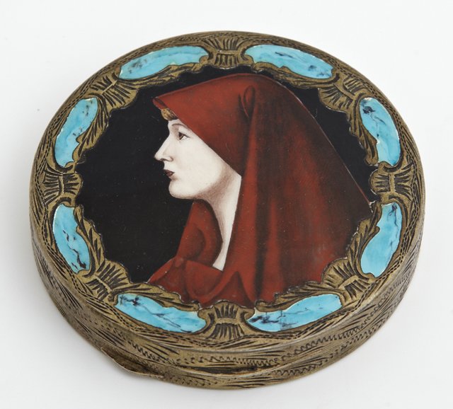 Continental Silver and Enamel Compact, c. 1900, the lid: Continental Silver and Enamel Compact, c. 1900, the lid with a portrait of a lady in a red cape with a faux turquoise border, the back with engraved floral and leaf decoration, H.- 9/16 in., Dia.- 2 3