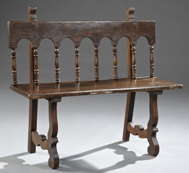 Spanish Carved Poplar Bench, c. 1850, with an arched: Spanish Carved Poplar Bench, c. 1850, with an arched spindled back, to a single board seat, on spoon carved trestle legs, H.- 37 3/4 in., W.- 43 in., D.- 15 in.