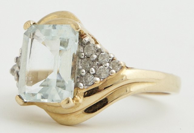 Lady's Vintage 14K Yellow Gold Dinner Ring, with an: Lady's Vintage 14K Yellow Gold Dinner Ring, with an emerald cut approximate 3 carat aquamarine, flanked by triangles mounted with six round diamonds each, size 7 1/4, Wt.- .16 troy oz.