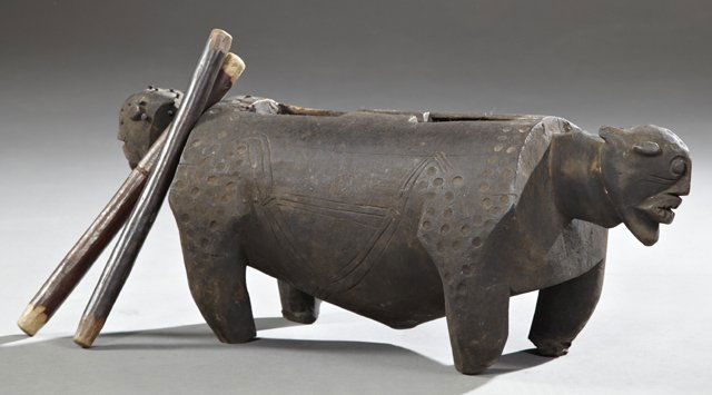 African Carved Wooden Figural Drum, early 20th c.,: African Carved Wooden Figural Drum, early 20th c., carved from a single log, the ends carved with animal heads, with two wooden drumsticks, H.- 10 in., W.- 26 in., D.- 10 in.
