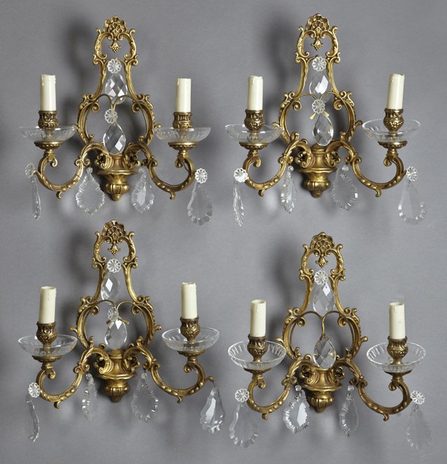 Set of Four Louis XV Style Bronze and Crystal Two Light: Set of Four Louis XV Style Bronze and Crystal Two Light Sconces, 20th c., with open lyre form back plates issuing relief decorated arms hung with prisms, with crystal bobeches, H.- 13 in., W.- 13 1/2 