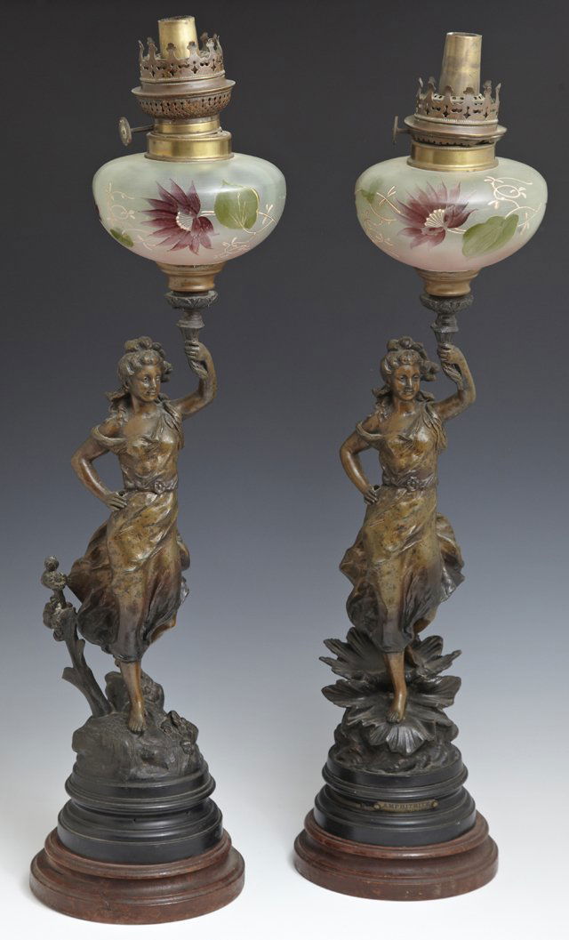 Pair of Art Nouveau Patinated Spelter Figural Oil: Pair of Art Nouveau Patinated Spelter Figural Oil Lamps, c. 1890, of "Amphitre" by Charles Levy, the figures upholding frosted glass fonts with enameled floral painting, on integral stepped plinths, o