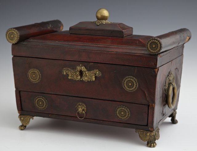 Ormolu Mounted Leather Covered Dresser Box, 19th c.,: Ormolu Mounted Leather Covered Dresser Box, 19th c., the stepped lid with "bolster" edges over open storage and a bottom drawer, the sides with ormolu ring handles, the whole on ormolu paw feet, H.- 8
