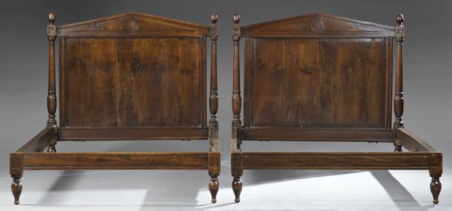 Pair of Directoire Style Carved Walnut Beds, late 19th: Pair of Directoire Style Carved Walnut Beds, late 19th c., the headboards with pointed pediments with applied geometric detail, flanked by turned and tapered supports on baluster form feet, the footbo