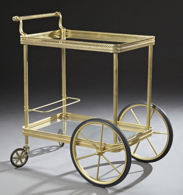 French Brass Tea Trolley, 20th c., the glass top within: French Brass Tea Trolley, 20th c., the glass top within a pierced galleried edge, with a reeded handle and supports, over a lower galleried shelf, on four wheels, H.- 31 1/2 in., W.- 18 in., D.- 24 1/