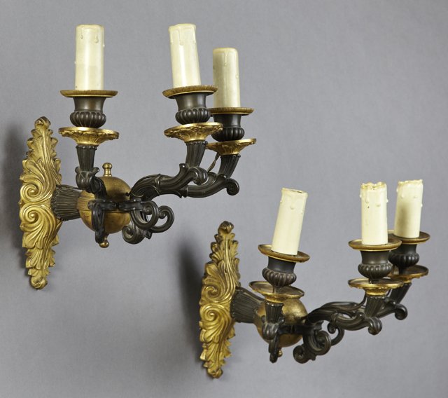 Pair of Fine French Empire Style Gilt and Patinated: Pair of Fine French Empire Style Gilt and Patinated Bronze Three Light Wall Sconces, 19th c., with shaped relief leaf decorated back plates issuing an orb mounted with three patinated scrolled relief