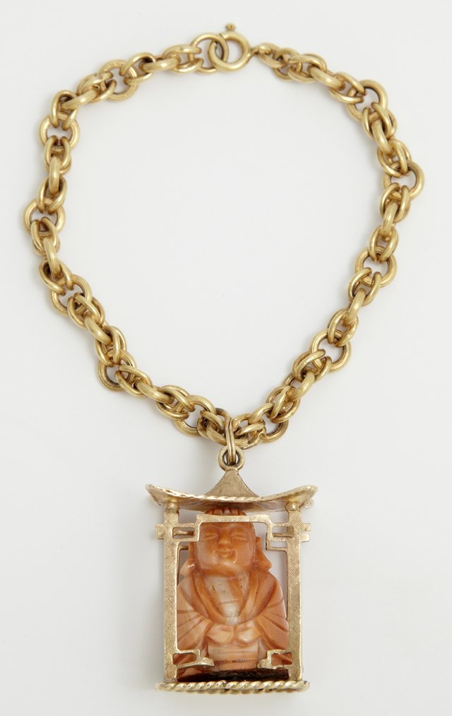18K Yellow Gold Link Bracelet, with an 18K Pendant: 18K Yellow Gold Link Bracelet, with an 18K yellow gold pendant altar charm, containing a carved angel skin coral Buddha figure, Charm- H.-1 1/4 in., Buddha- H.- 9/16 in., Bracelet Wt.- .18 troy oz.