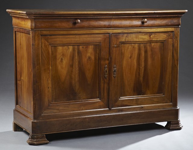 Louis Philippe Carved Walnut Sideboard, c. 1850, the: Louis Philippe Carved Walnut Sideboard, c. 1850, the canted corner ogee edge top, above two frieze drawers, over double paneled cabinet doors, flanked by canted corners, to a plinth base, on ogee brac