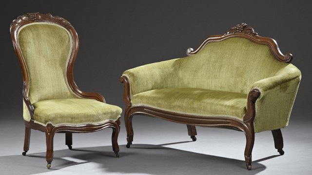 American Victorian Rococo Revival Carved Mahogany Two: American Victorian Rococo Revival Carved Mahogany Two Piece Parlor Suite, c. 1900, consisting of a slipper chair and a roll arm settee both with a carved grape crest over shaped backs, on reeded cabri