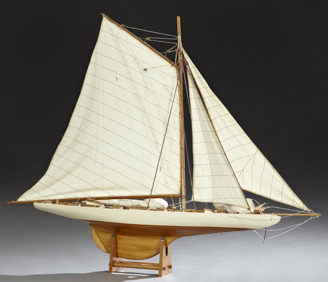 Carved Mahogany Pond Sailboat, 20th c., of a cutter,: Carved Mahogany Pond Sailboat, 20th c., of a cutter, with five sails, on a custom mahogany stand, H.- 41 in., W.- 48 1/2 in., D.- 6 1/2 in.