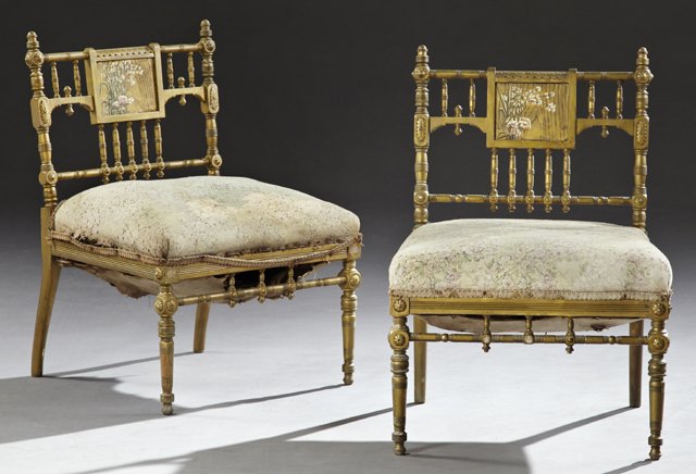 Pair of American Aesthetic Carved Giltwood Slipper: Pair of American Aesthetic Carved Giltwood Slipper Chairs, c. 1880, the spindled backs with central floral painted plaques, on ring turned supports to ring turned tapered legs, joined by a spindled ri