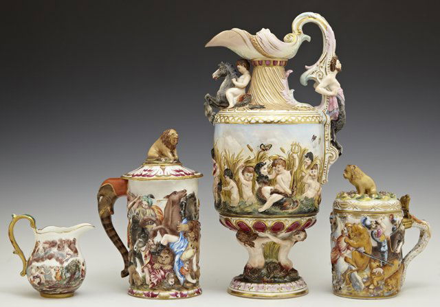 Four Pieces of Capodimonte, 20th c., consisting of a: Four Pieces of Capodimonte, 20th c., consisting of a lidded tankard, and a covered tankard, both with relief battle scenes, a cream pitcher with putti in the clouds, and a large ewer with a satyr hand