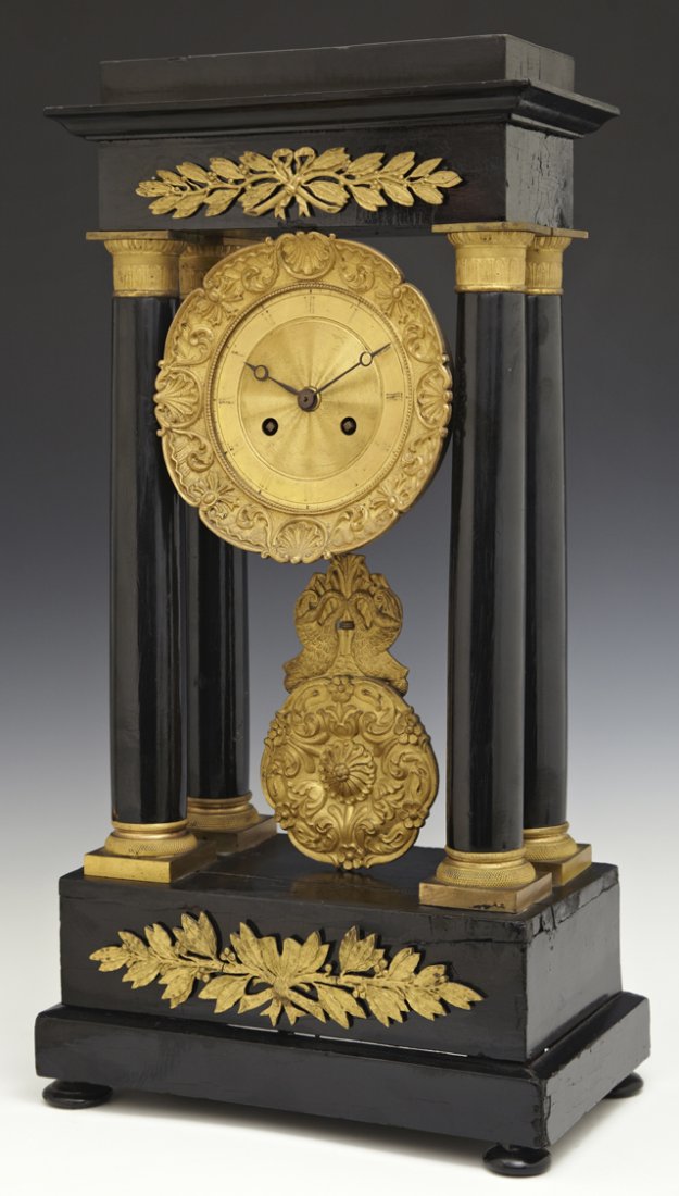 French Ebonized Gilt Bronze Ormolu Mounted Portico: French Ebonized Gilt Bronze Ormolu Mounted Portico Clock, mid 19th c., the stepped top over a gilt bronze scroll and shell relief bordered clock, with columns with gilt ormolu capitals, the gilt bronz