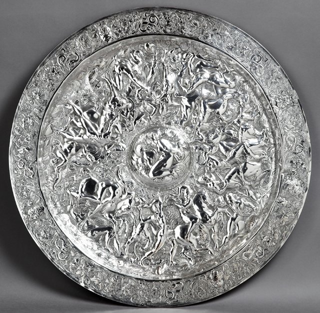 Large Continental Repousse Silver Plate on Copper: Large Continental Repousse Silver Plate on Copper Plaque, of circular shield form, the wide flat rim with a repousse band of flowers, dragons, squirrels and grotesque masks, around a repousse band of 