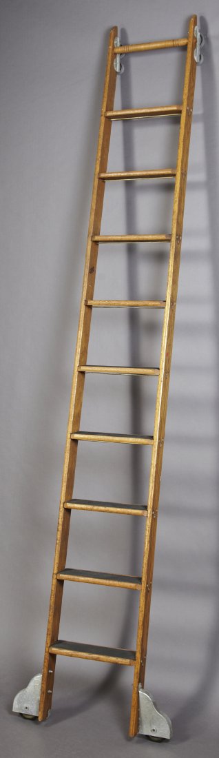American Carved Oak Libary Ladder, early 20th c., by: American Carved Oak Libary Ladder, early 20th c., by the Putnam Rolling Ladder Co., New York, with nine steps on mounted casters, the top with track wheels, H.- 117 in., W.- 15 3/4 in., D.- 3 1/4 in.
