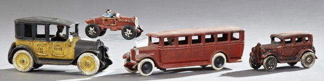 Group of Four Cast Iron Toys, 20th c., one a red bus by: Group of Four Cast Iron Toys, 20th c., one a red bus by Skoglund and Olson; one an Arcade Yellow Cab; one a racecar, and a sedan, Yellow Cab- H.- 4 3/8 in., W.- 3 1/6 in., D.- 8 1/2 in. (4 Pcs.)