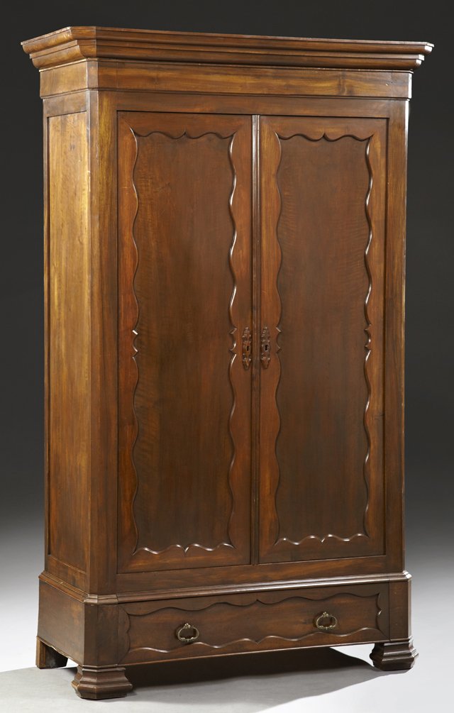 Louis Philippe Style Carved Walnut Armoire, c. 1900,: Louis Philippe Style Carved Walnut Armoire, c. 1900, the stepped canted corner ogee crown over double doors with serpentine edge inset panels, over a long drawer, on stepped ogee bracket feet, H.- 85 
