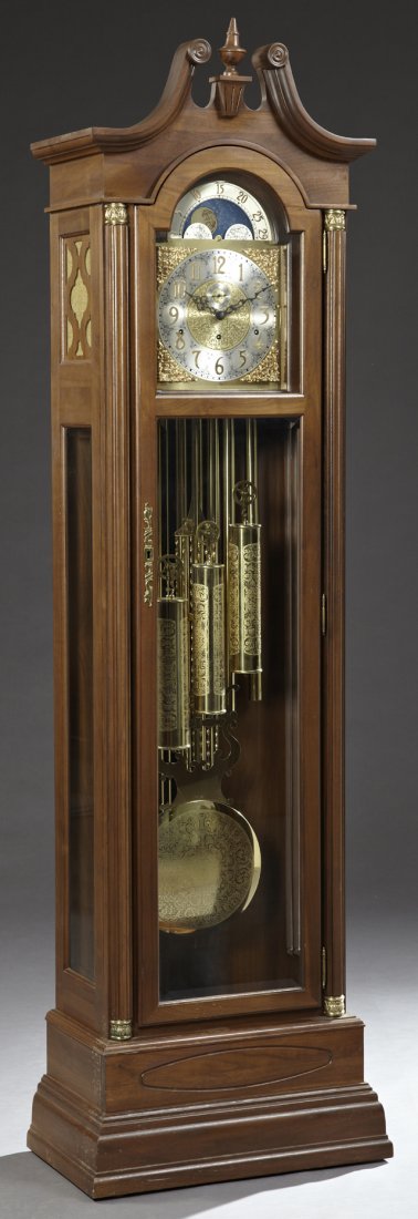 American Ormolu Mounted Carved Walnut Tall Case Clock,: American Ormolu Mounted Carved Walnut Tall Case Clock, 20th c., by The King Arthur Clock Co., the broken arch pediment over an arched beveled clock window, opening to a moon dial over a polished brass