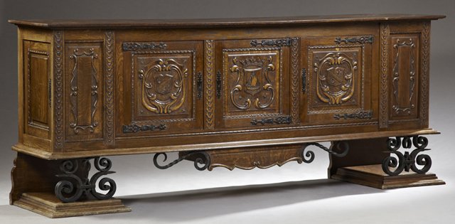 Spanish Style Carved Quarter Sawn Oak and Wrought Iron: Spanish Style Carved Quarter Sawn Oak and Wrought Iron Sideboard, early 20th c., the inlaid top, over three fielded panel cupboard doors with wrought iron escutcheons and hinges, decorated with carved