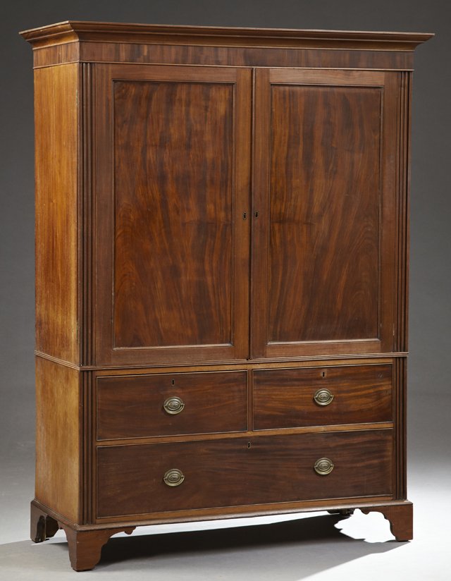 English Georgian Style Carved Mahogany Linen Press,: English Georgian Style Carved Mahogany Linen Press, 19th c., the stepped crown over double cupboard doors opening to five slides, flanked by reeded stiles, on a base with two frieze drawers over a lon