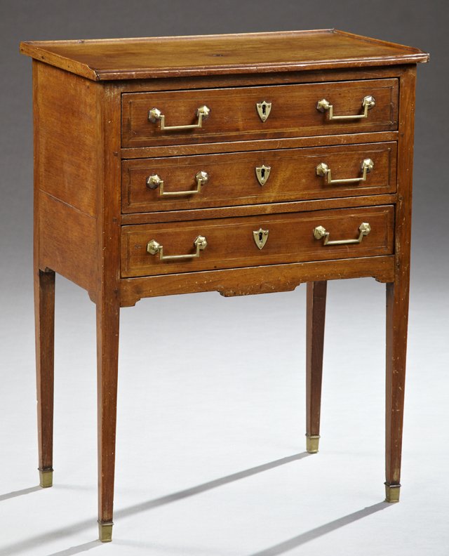 French Directoire Style Carved Mahogany Nightstand,: French Directoire Style Carved Mahogany Nightstand, 19th c., the three-quarter galleried top over three inlaid drawers with brass shield form escutcheons and pulls, on tapered square legs to brass sab