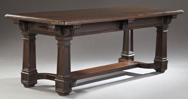 American Empire Style Carved Mahogany Library Table,: American Empire Style Carved Mahogany Library Table, late 19th c., the stepped curved corner rectangular top, over a wide skirt with two end drawers, on square tapered legs on square feet, joined by a