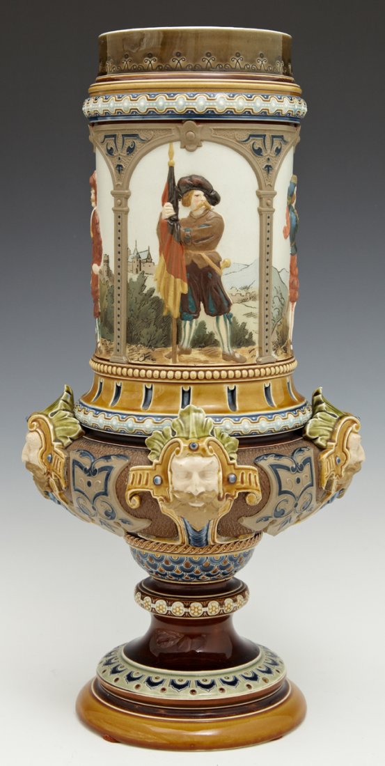 Mettlach Pokal, c. 1890, #1820, by Villeroy and Boch,: Mettlach Pokal, c. 1890, #1820, by Villeroy and Boch, with four figural panels above four relief masks, now lacking the lid, H.- 14 in., Dia.- 7 1/4 in. Note: This Piece is Illustrated in the "Book of