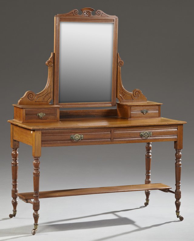 English Edwardian Carved Mahogany Dressing Table, c.: English Edwardian Carved Mahogany Dressing Table, c. 1900, the broken arch crown over a wide beveled mirror, flanked by two glove boxes, on a base with two reeded frieze drawers, on tapered ring turne