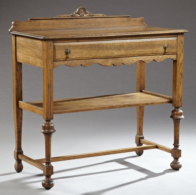 Arts and Crafts Carved Oak Server, c, 1900, the applied: Arts and Crafts Carved Oak Server, c, 1900, the applied shell carved serpentine splash over a rectangular stepped top, above a frieze drawer over an open shelf on tapered ring turned legs to ball feet