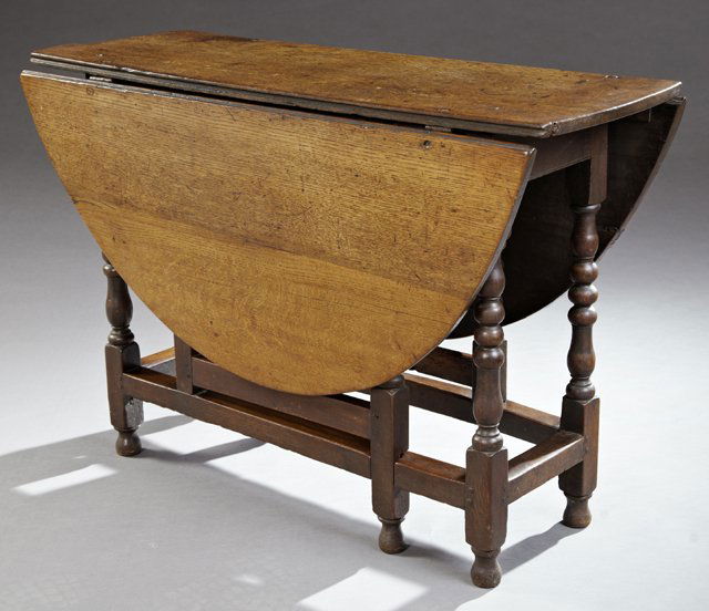 William and Mary Style Carved Oak Drop Leaf Gate-Leg: William and Mary Style Carved Oak Drop Leaf Gate-Leg Table, 19th c., the oval top on tapered bobbin turned legs with tapered turned feet, joined by a box stretcher, Closed- H.- 28 3/4 in., W.- 16 1/4
