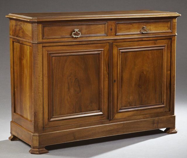 French Louis Philippe Carved Walnut Sideboard, 19th c.,: French Louis Philippe Carved Walnut Sideboard, 19th c., the stepped canted corner top over two frieze drawers above two cupboard doors, flanked by chamfered stiles, on a plinth base to ogee feet, H.- 