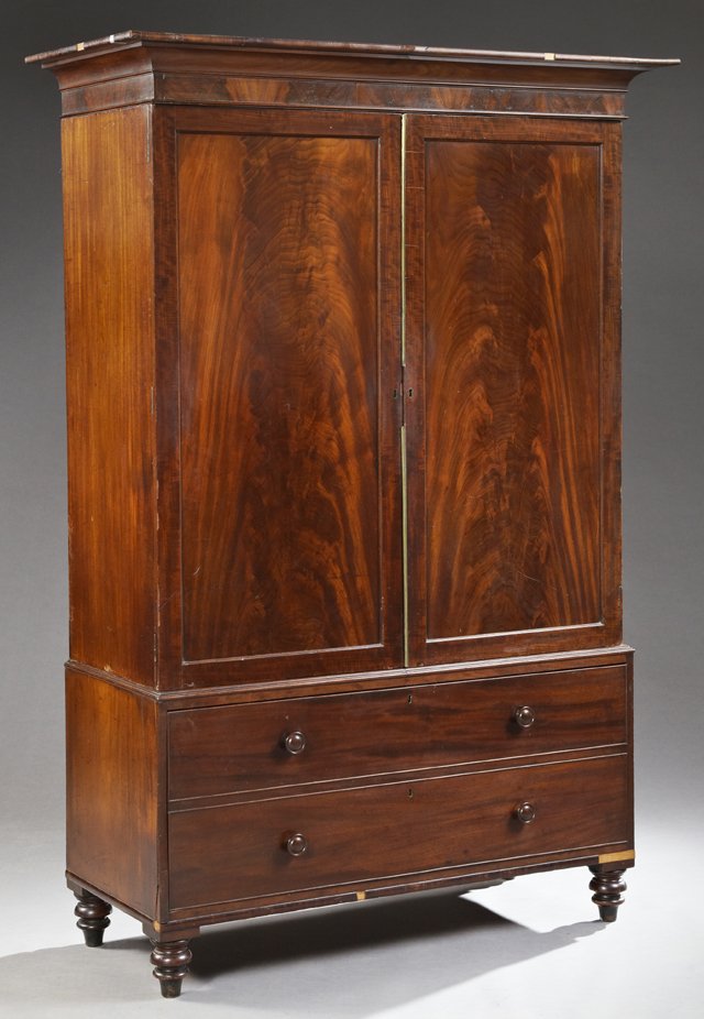 English Victorian Carved Mahogany Linen Press, 19th c.,: English Victorian Carved Mahogany Linen Press, 19th c., the stepped cavetto crown above double inset panel cupboard doors with brass edges, on a base with a single deep double faux drawer, on ring tur